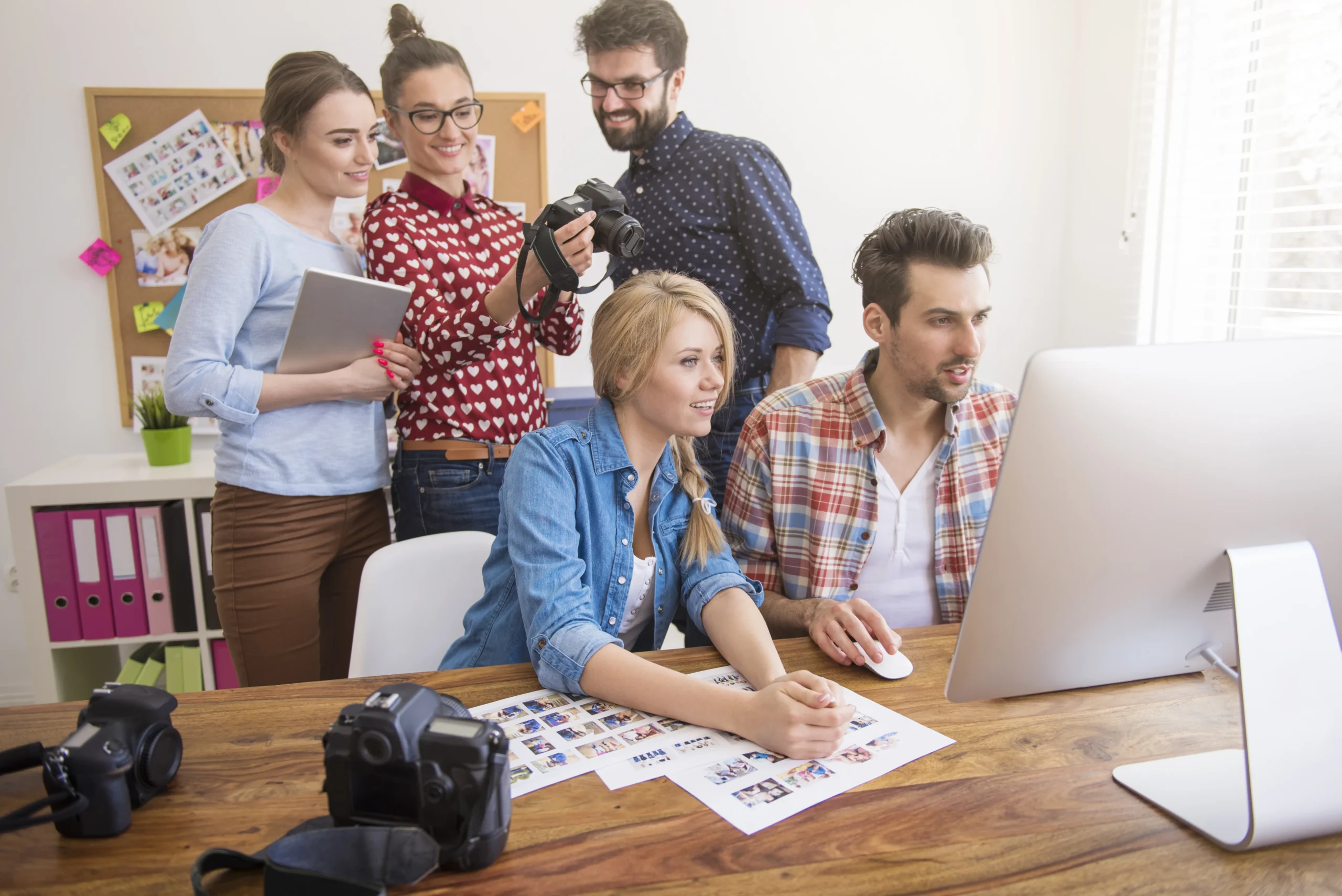 A group of young professionals working on a creative project in an office